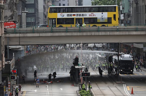 Police water canon trucks spray water to disperse protesters during a rally against the implementation of a new national security law in Causeway Bay, Hong Kong, China.