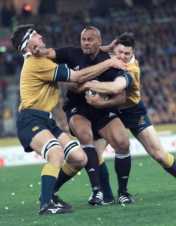 John Eales and Matthew Burke attempt to tackle Jonah Lomu.