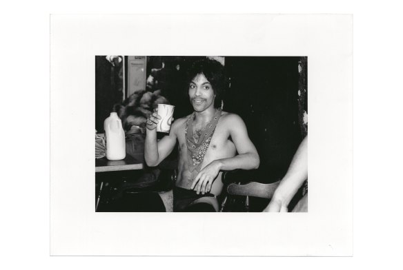 Prince sips some orange juice backstage during the Dirty Mind tour, 1981. 
