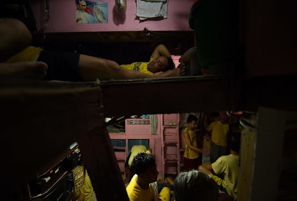 Inmates sleep in a ceiling loft in a cell assigned to inmates not affiliated to gangs in Quezon City Jail, Manila, Philippines.