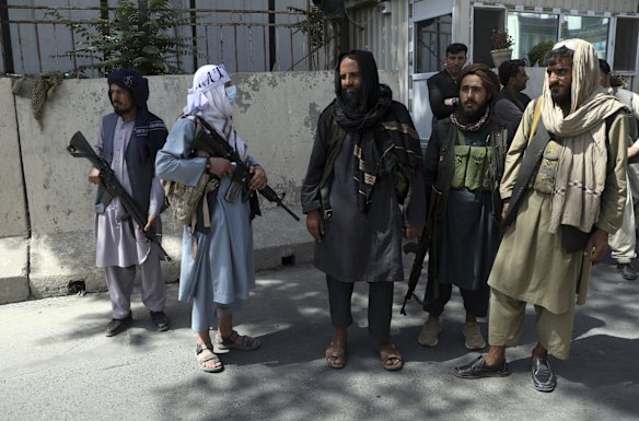Taliban fighters stand guard at the main gate leading to the Afghan presidential palace, in Kabul, Afghanistan. The U.S. military struggled to manage a chaotic evacuation from Afghanistan on Monday as the Taliban patrolled the capital and tried to project calm after toppling the Western-backed government. 