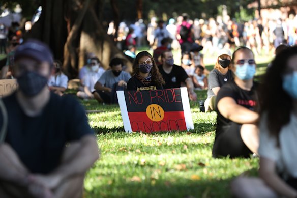 People sit peacefully at the Invasion Day Rally held at The Domain.