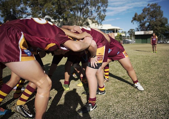 The team practices a scrum play prior to the start of the game.