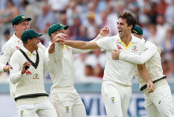 Pat Cummins celebrates with teammates after taking the wicket of England's Joe Root.