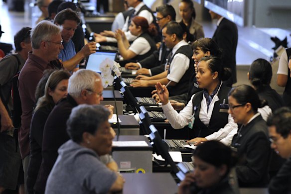 Qantas Airways personnel talk with passengers at Los Angeles International Airport (LAX).