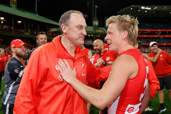 Men on a mission: John Longmire and Isaac Heeney celebrate Sydney’s win on Friday night.