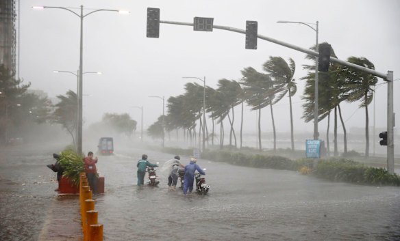Motorists brave the rain and strong winds brought about by Typhoon Mangkhut which barreled into northeastern Philippines before dawn Saturday, Sept. 15, 2018.