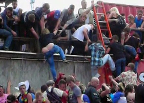 In this image taken from television, people are seen trying to escape over a wall  after a panic on this year's Love Parade.