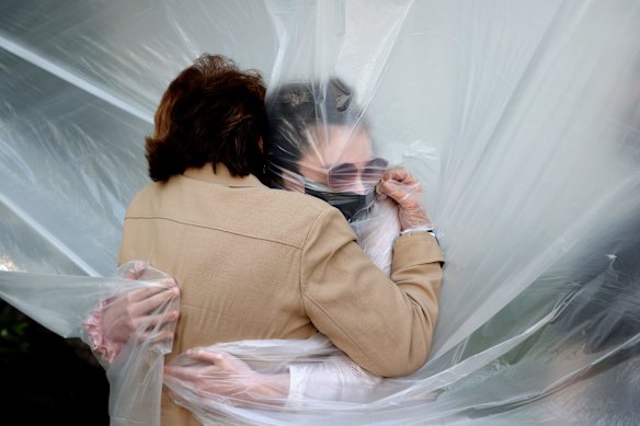 Olivia Grant hugs her grandmother, Mary Grace Sileo through a plastic drop cloth hung up on a homemade clothes line during Memorial Day Weekend on May 24, 2020 in Wantagh, New York. It was the first time they had contact of any kind since the COVID-19 pandemic lockdown started in late February 2020.