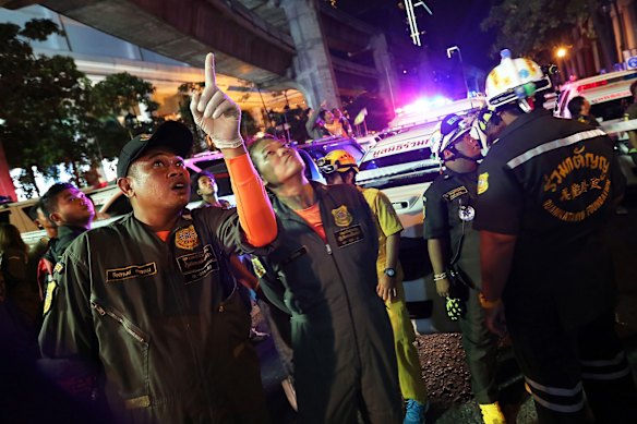 An emergency responder points whilst speaking with his colleague following an explosion at the Ratchaprasong intersection in Bangkok, Thailand, on Monday, Aug. 17, 2015. 