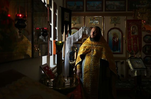 Priest Fr Oleg Aliluyko in his church in the village of Rassypnoe.