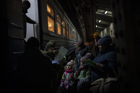 Displaced Ukrainians queue to board a Poland bound train in Lviv, western Ukraine.