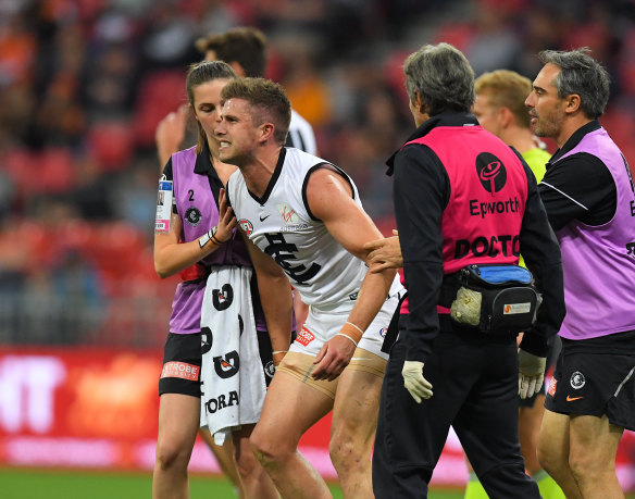 Crunched: Marc Murphy leaves the field after being hit by Giant ruckman Shane Mumford.