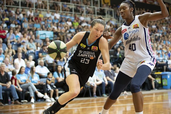 The Capitals' Kelsey Griffin drives past the Adelaide Lightning's Kayla Alexander. 
