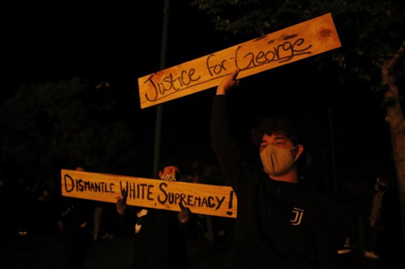 Protesters gather outside the burning Minneapolis police 3rd Precinct building.
