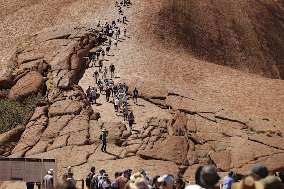 Visitors climbing up Uluru on the final day the climb is allowed.