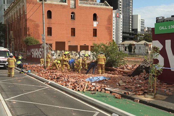 Firemen and workers with bare hands frantically remove the fallen bricks.