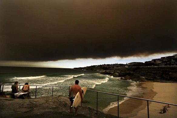 People watch from Tamarama as a wave of smoke haze smothers the Eastern suburbs of Sydney, caused by bush fires across Sydney and NSW.