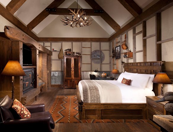 In keeping with the outdoors theme, the room has the look and feel of a hunting lodge, complete with mounted deer head on the wall and lamps made from antlers. 