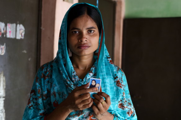 Bangladesh textile worker Tania, 21, holds the only photo of her daughter who lives in a distant village with her grandparents.