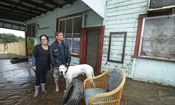Trish Whitehead and Rory Freeman with dog Bomber, who were rescued by SES from the awning of their home.