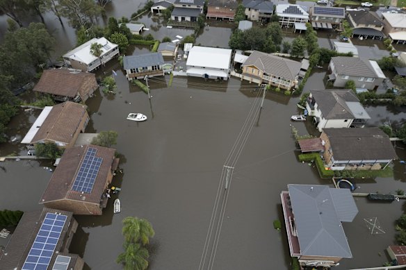 Heavy flooding in Mawson Place, Pitt Town.  Every house in the street is underwater up to the first level.