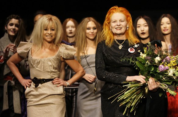 British designer Vivienne Westwood, foreground right, holds flowers as she takes her bow next to Jo Wood, left, during her catwalk show at London Fashion Week, in west London, Saturday, Feb. 21, 2009. 