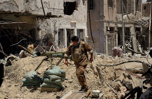 Lieutenant Colonel Saaed Beder Kathem runs away from the blast range of a planned detonation of one of six IED's on a road in West Mosul.