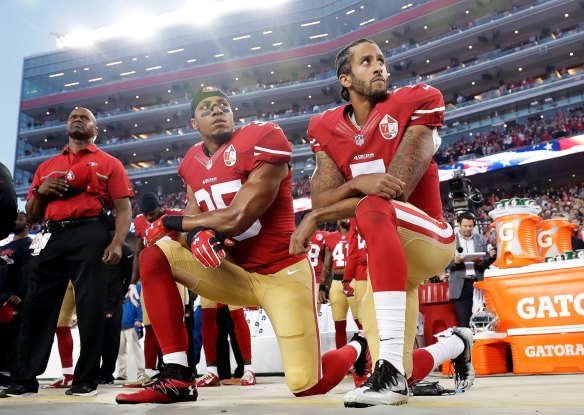 Colin Kaepernick, right, and Eric Reid take a knee during the US national anthem in 2016.