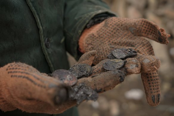 Serhiy Malyshenko, a decorated veteran of the Soviet war in Afghanistan, holds his military medals that he retrieved from the ruins of his house, destroyed during fighting between Russian and Ukrainian forces in the village of Yasnohorodka, on the outskirts of Kyiv.