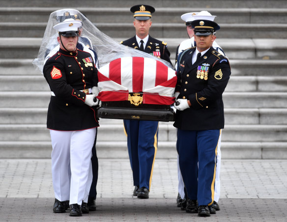 The casket of John McCain is carried down the steps of the US Capitol.