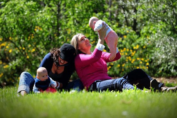 Canberra Capitals coach Carrie Graf, with partner Camille Chicheportische and baby twins Bentley (in blue ) and Charli (in red).