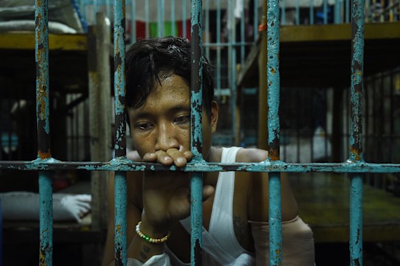 Wounded drug user Francisco Maneja 27, sits in a cell at Manila Police Headquarters.