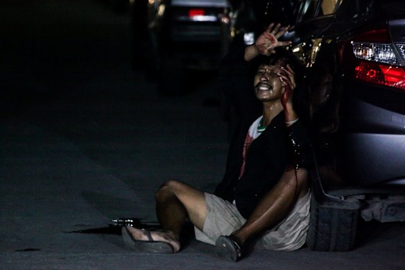 Francisco Maneja 27, bleedingfrom gun shot wounds raises his hands in surrender whilst yelling 'help me help me' after being shot during a drug operation and playing dead for hours in Manila . Francisco, a father of two, now faces years in jail. Manila, Philippines.
