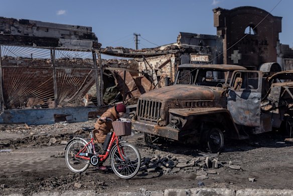 A woman pushes her bike past destroyed Russian vehicles close to the central train station that was used as a Russian base in Trostyanets, Ukraine. Ukrainian forces announced this week that they had retaken Trostyanets, a northeastern town that has seen fierce fighting and was occupied by Russians for weeks.