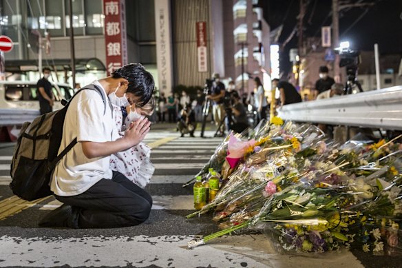 People pray at a site outside of Yamato-Saidaiji Station where Japan's former prime minister Shinzo Abe was shot.