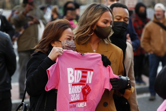 Chrissy Teigen, center, and her mother Vilailuck Teigen shop for President Joe Biden and Vice President Kamala Harris and John Legend souvenirs during 59th Presidential Inauguration, Wednesday, Jan. 20, 2021, in Washington.