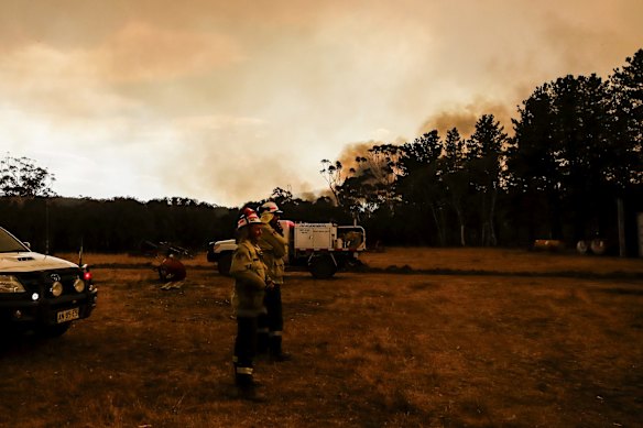 Fire crews work to defend Bombay resident Les Hart's property as the North Black Range bushfire approaches, seen near Bombay, NSW.