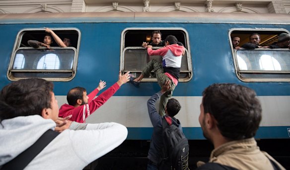 Migrants board trains in Keleti station after it was reopened this morning in central Budapest.