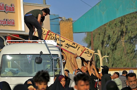 Mourners unload the coffin of a victim of the Monday bombing at a Baghdad market that was busy with shoppers a day before the Muslim Eid al-Adha holiday, in preparation for the burial in Najaf, Iraq. Iraqi medical officials said the bomb attack in Sadr City, a Baghdad suburb, killed at least 30 people and wounded dozens of others. 