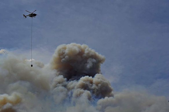 A helicopter assists to help put out a major bushfire on Mount Forest Road near Cooma.