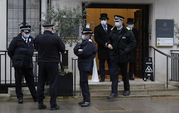 Police officers stand outside the King Edward VII hospital in London, Wednesday, Feb. 17, 2021. Buckingham Palace says 99-year-old Prince Philip has been admitted to a London hospital after feeling unwell. 