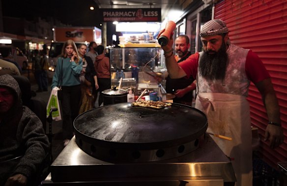 A vendor puts the finishing touches to his food on Haldon Street.