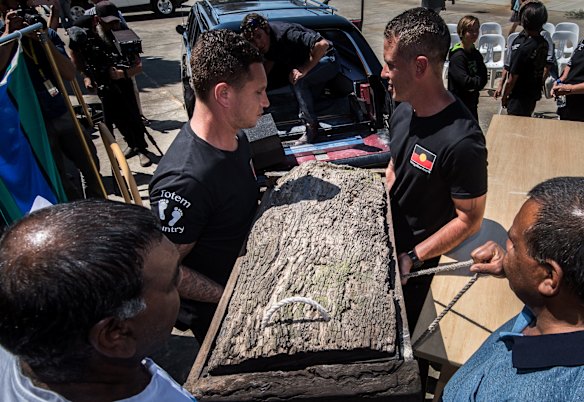 Mungo Man's remains in a red gum box are loaded into the hearse.