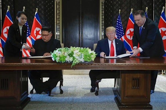 North Korea leader Kim Jong Un and U.S. President Donald Trump prepare to sign a document at the Capella resort on Sentosa Island.