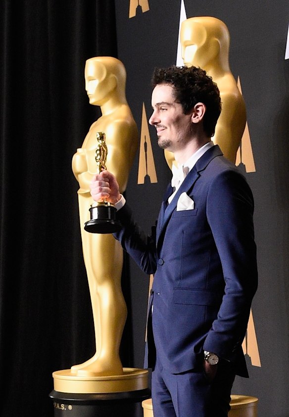 Damien Chazelle poses with his Oscar for best director for <i>La La Land</i>.