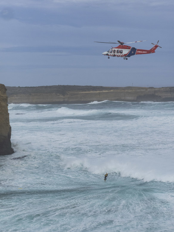 An emergency helicopter winches a person out of the water on the day of the incident.