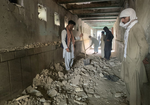 People inspect the inside of a mosque following a suicide bombers attack in the city of Kandahar.