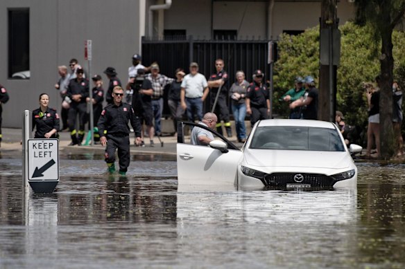 A driver abandons his car after attempting to drive on a flooded road, Friday November 4, 2022.