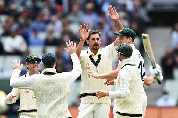 Mitchell Starc celebrates with teammates after dismissing England captain Joe Root.